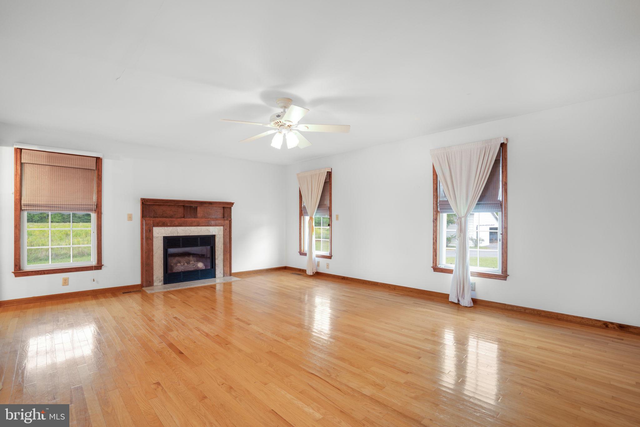 9449 Carey Road Berlin, MD 21811 - Photo 80 of 108 an empty room with wooden floor fireplace and windows