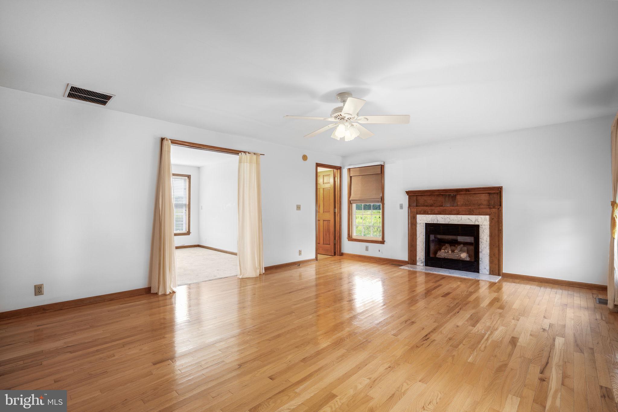 9449 Carey Road Berlin, MD 21811 - Photo 81 of 108 an empty room with wooden floor fireplace and windows