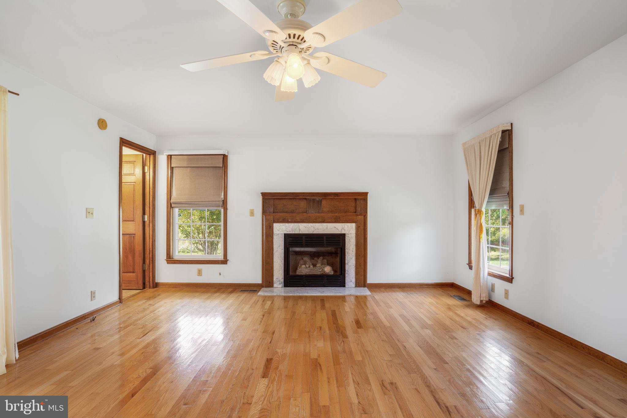 9449 Carey Road Berlin, MD 21811 - Photo 82 of 108 an empty room with windows fireplace and wooden floor