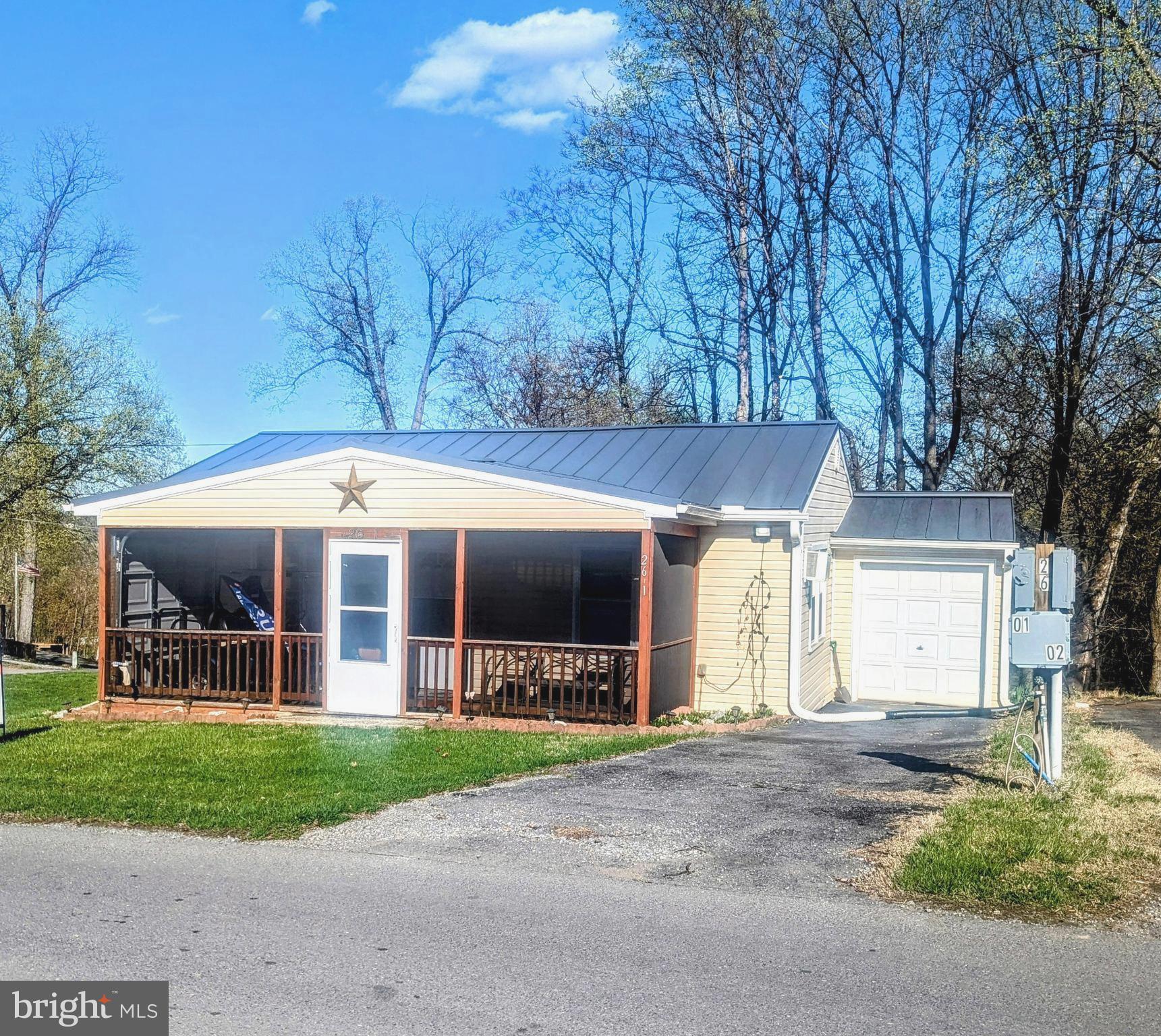 a view of a house with a yard and potted plants