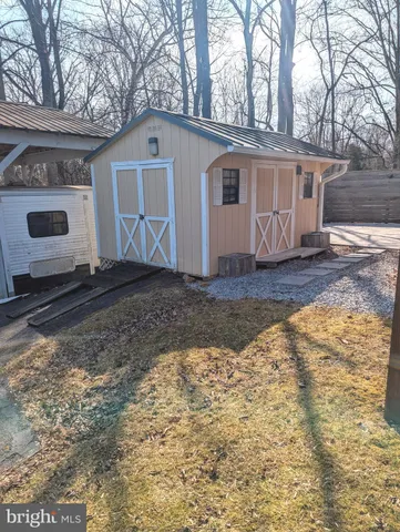 a view of a grey house with a yard