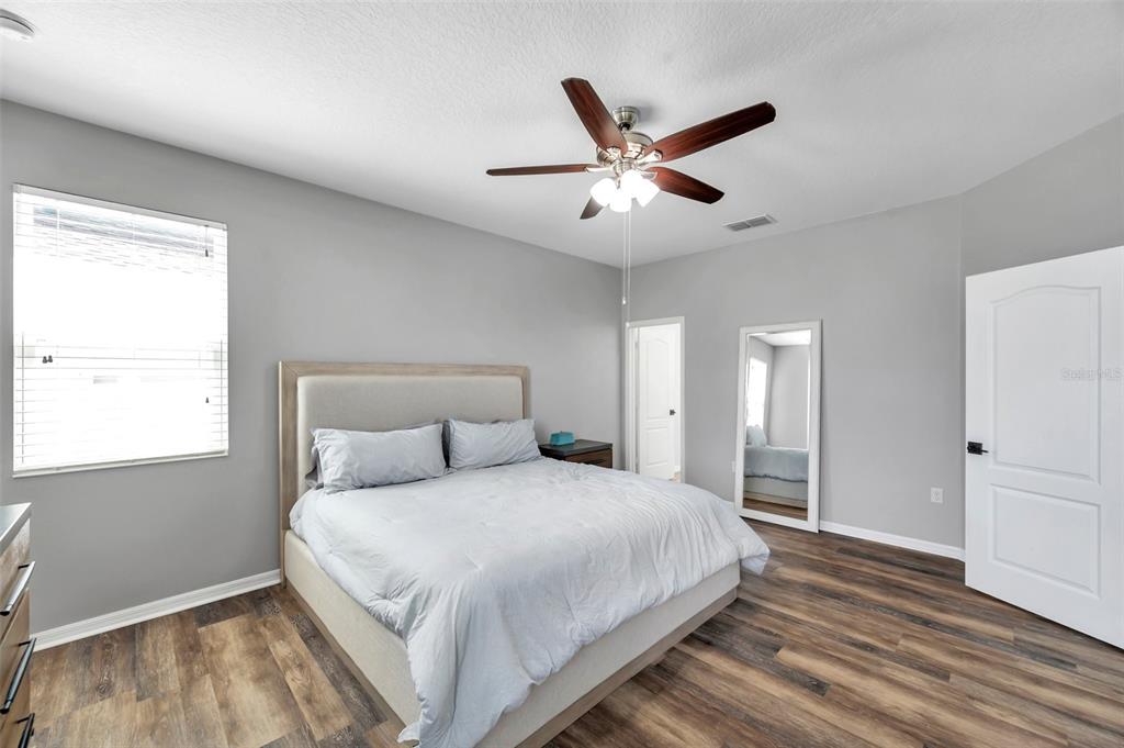 7523 Tangle Brook Boulevard Gibsonton, FL 33534 - Photo 15 of 35 a bedroom with a large bed and a chandelier