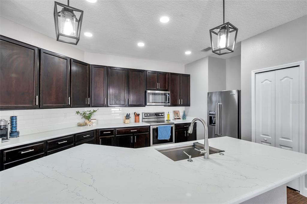 7523 Tangle Brook Boulevard Gibsonton, FL 33534 - Photo 7 of 35 a kitchen with stainless steel appliances a refrigerator sink and wooden cabinets