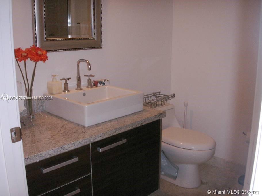 185 Southwest 7th Street, Unit 1906 Miami, FL 33130 - Photo 4 of 11 a bathroom with a sink and a toilet