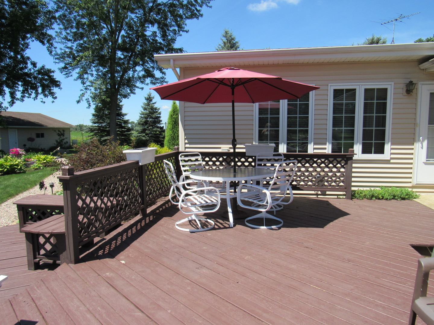 1027 West Kennedy Road Braidwood, IL 60408 - Photo 15 of 55 a view of a roof deck with table and chairs under an umbrella with wooden fence