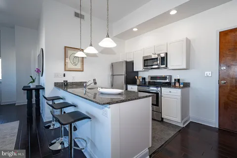 a kitchen with stainless steel appliances kitchen island a sink and cabinets