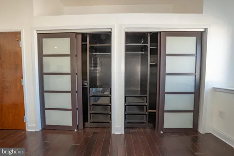 an empty room with wooden floor and closet