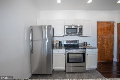 a kitchen with stainless steel appliances a refrigerator stove and microwave