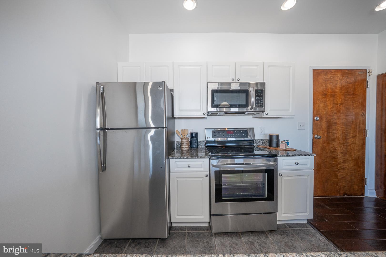 1001 Chestnut Street, Unit 705E Philadelphia, PA 19103 - Photo 20 of 36 a kitchen with stainless steel appliances a refrigerator stove and microwave