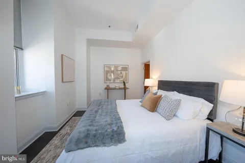 a bedroom with a bed and painting on the wall