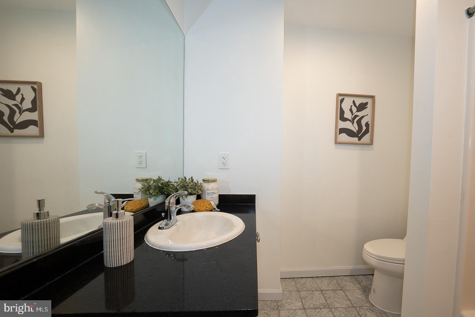 1001 Chestnut Street, Unit 705E Philadelphia, PA 19103 - Photo 29 of 36 a bathroom with a granite countertop sink and a mirror