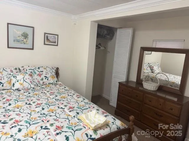 a bedroom with a bed and a mirror on dresser