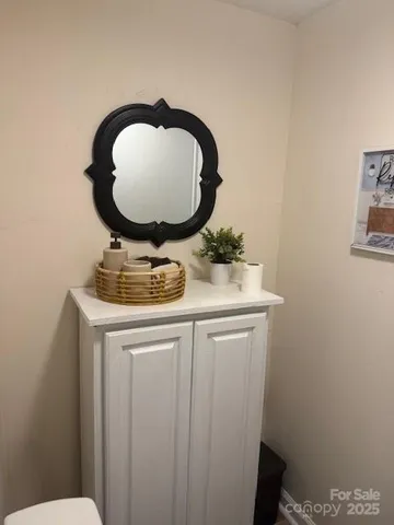 a bathroom with a toilet mirror vanity and a sink