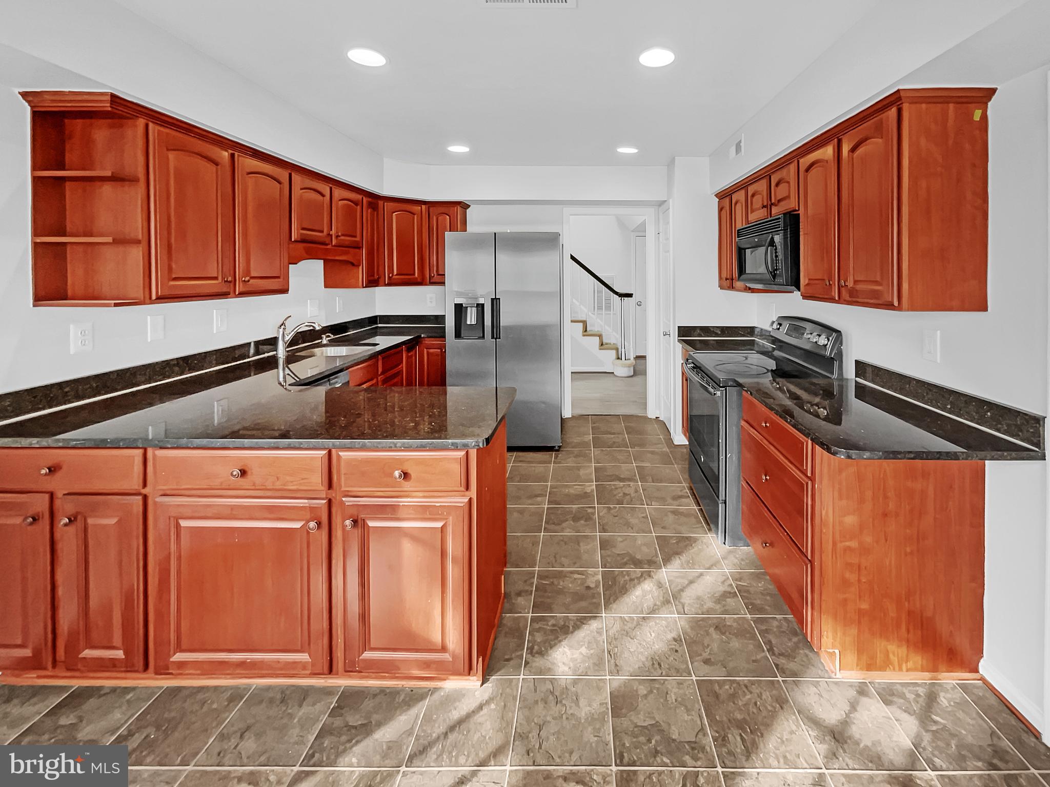 1624 Hiddenbrook Drive Herndon, VA 20170 - Photo 6 of 58 a kitchen with stainless steel appliances granite countertop a stove a sink and a microwave