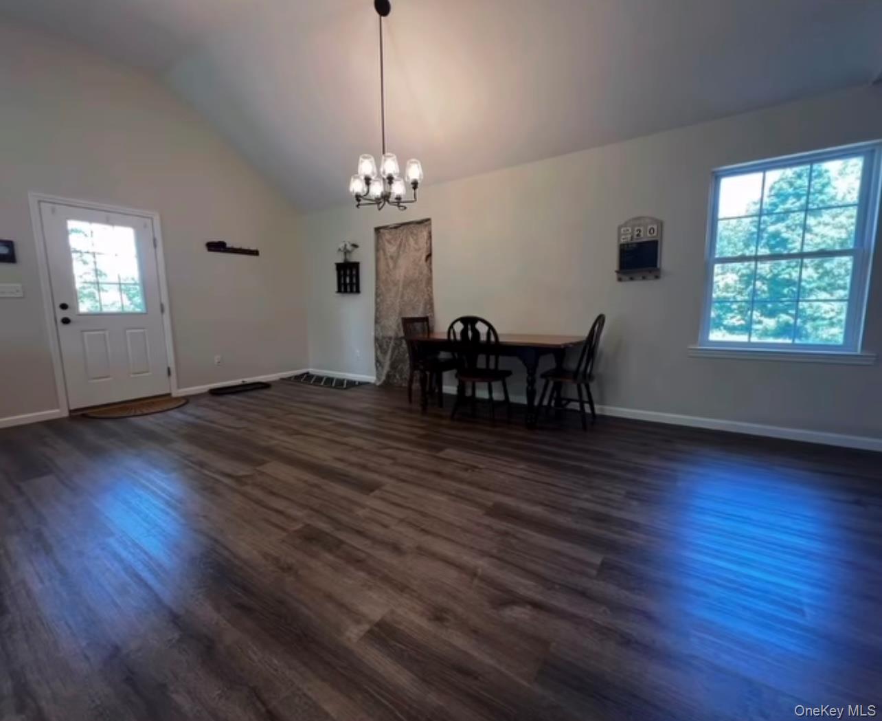 118 Plains Road, Unit 2 Walden, NY 12586 - Photo 3 of 15 a view of a dining room with hardwood floor a chandelier a wooden table and chairs