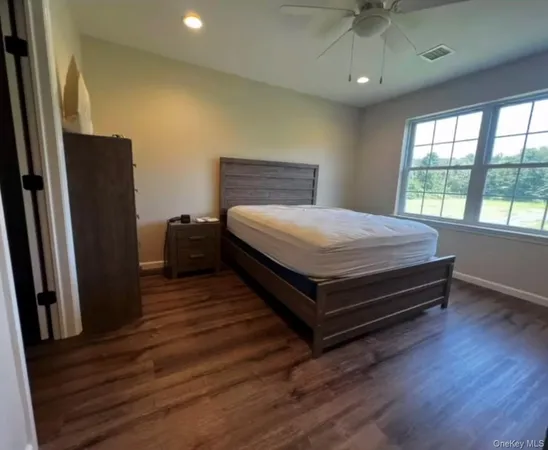 a bed sitting in a spacious bedroom next to a window