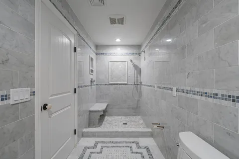 a bathroom with a shower a toilet and sink