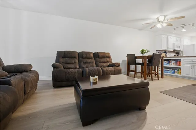 a living room with furniture a chandelier and a dining table