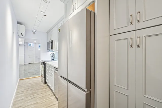 a kitchen with stainless steel appliances a refrigerator a sink and cabinets