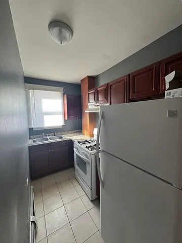 a kitchen with stainless steel appliances granite countertop a refrigerator and a stove