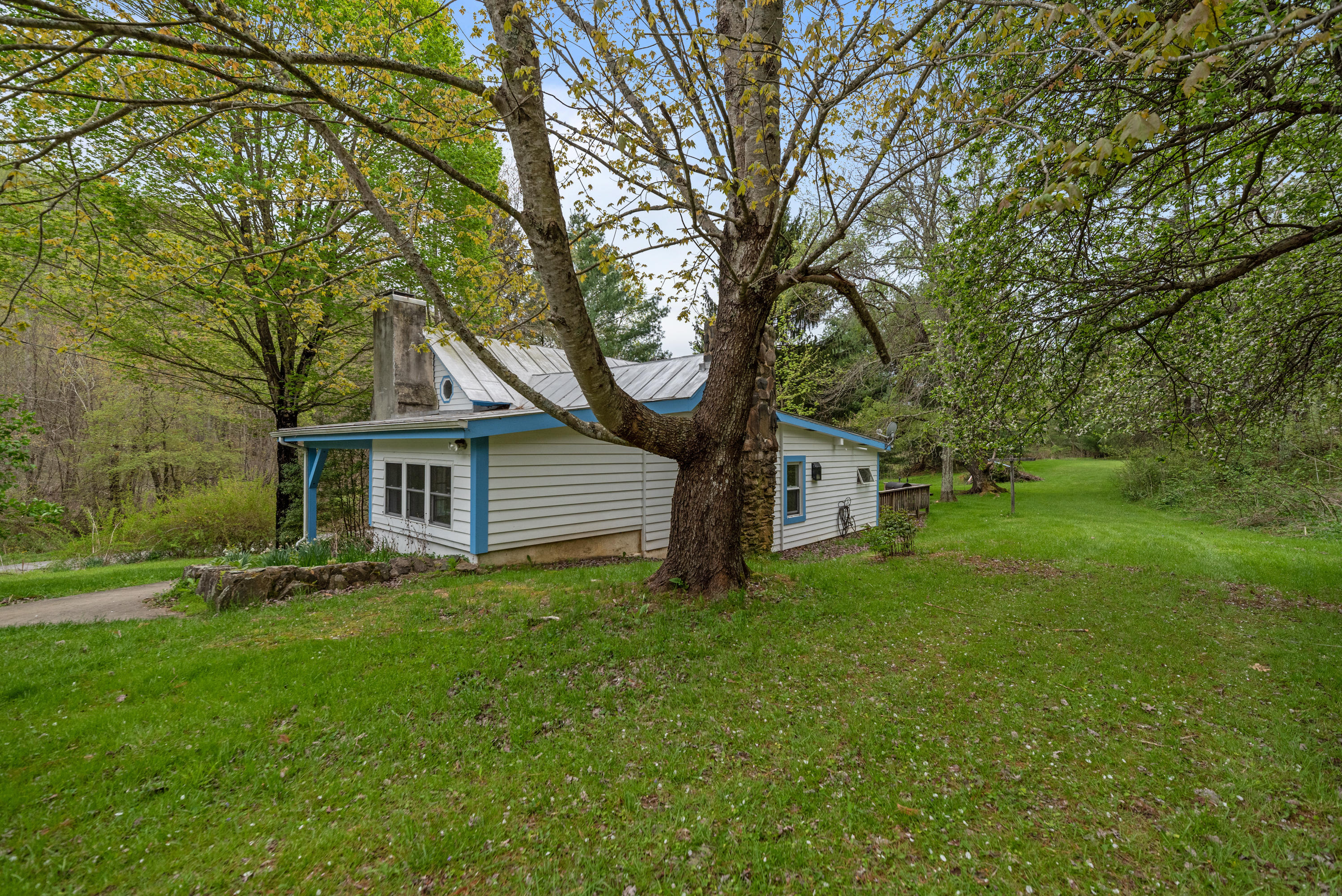 757 Halls Store Road Southwest Willis, VA 24380 - Photo 40 of 43 a white house that has a tree in front of it