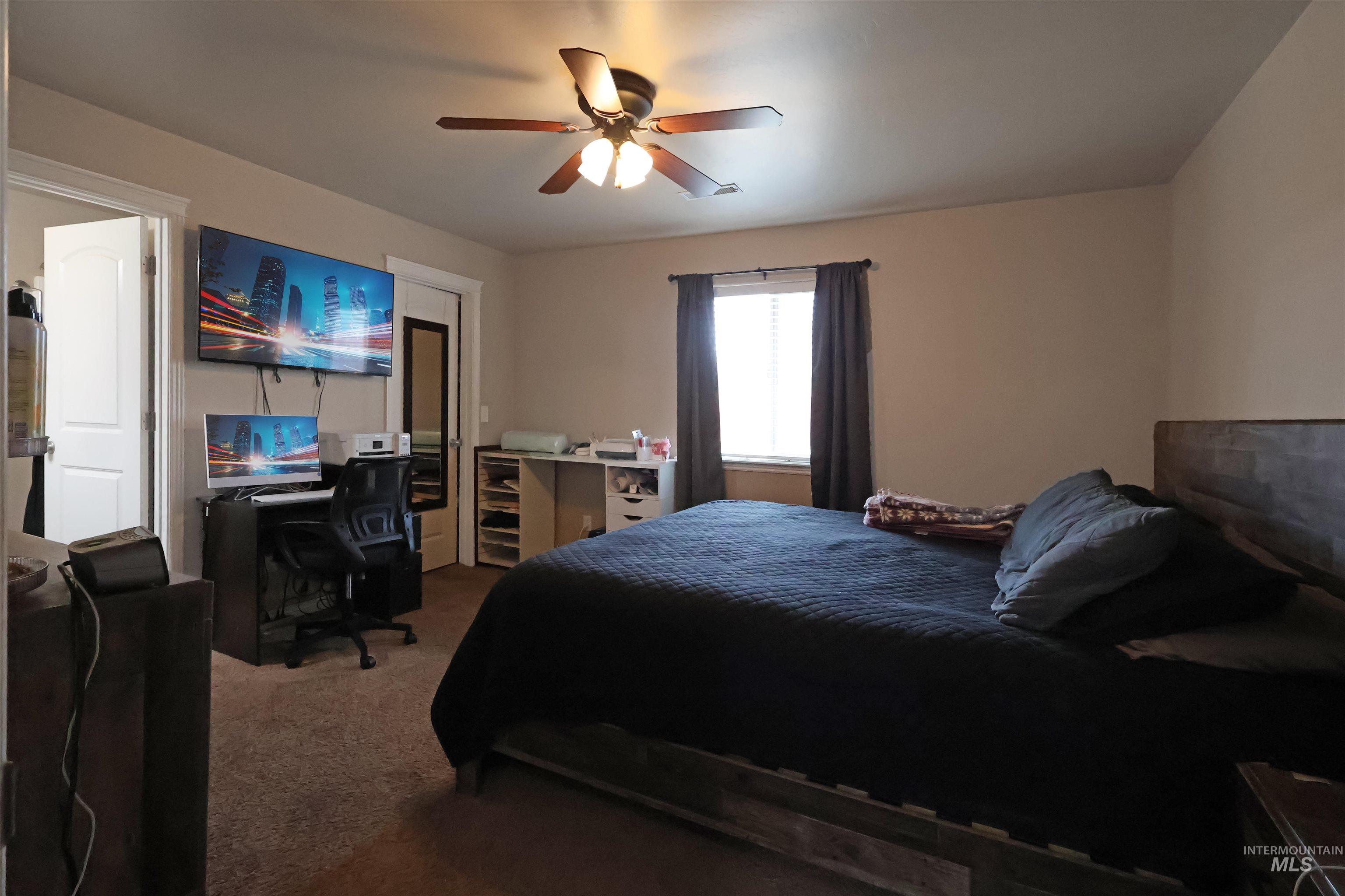 717 South B Street Rupert, ID 83350 - Photo 7 of 13 Bedroom featuring carpet flooring, a desk, and a ceiling fan