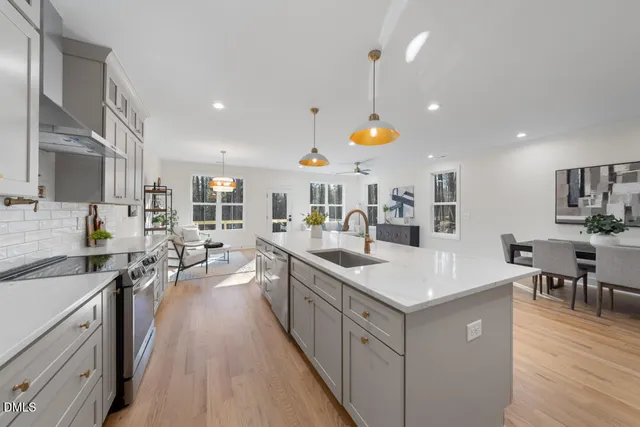 a large kitchen with stainless steel appliances a lot of counter space and wooden floor