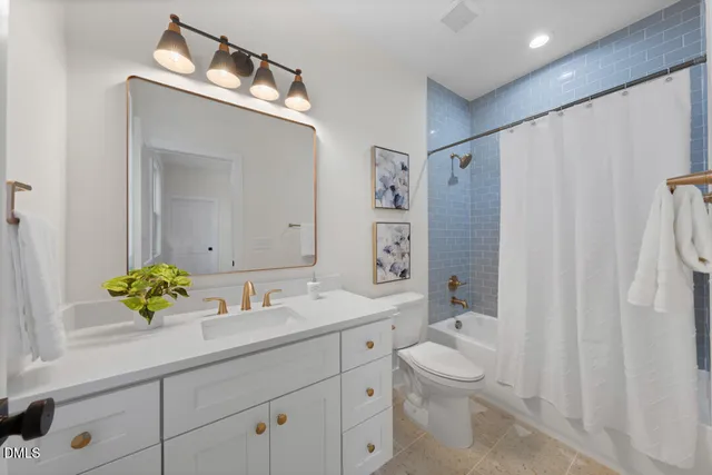 a bathroom with a granite countertop sink a toilet and mirror