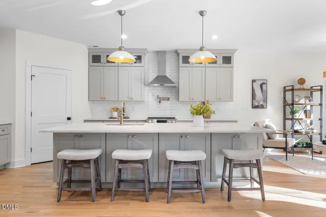 a kitchen with a dining table chairs cabinets and stainless steel appliances