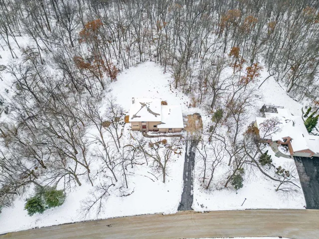 a kitchen with stainless steel appliances kitchen island granite countertop a refrigerator a stove top oven and a sink with wooden floor