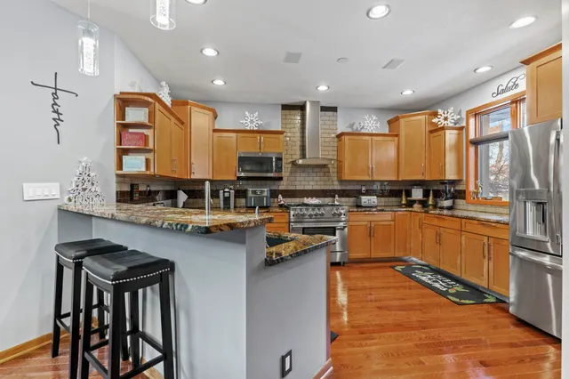 a kitchen with stainless steel appliances granite countertop a stove a sink and white cabinets