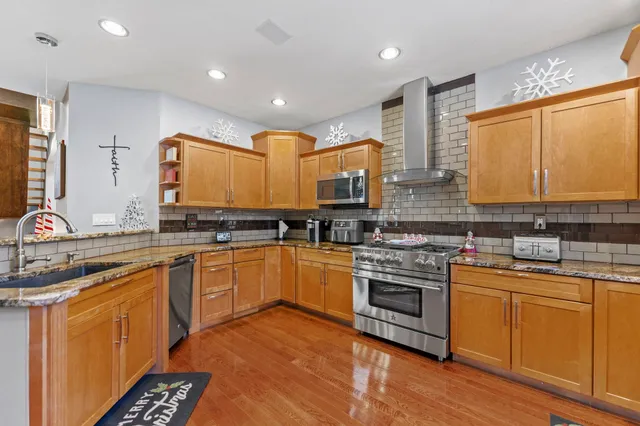 a kitchen with stainless steel appliances granite countertop a refrigerator and a stove