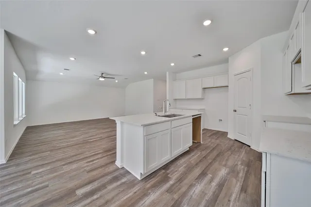 a large kitchen with a lot of counter space and wooden floor