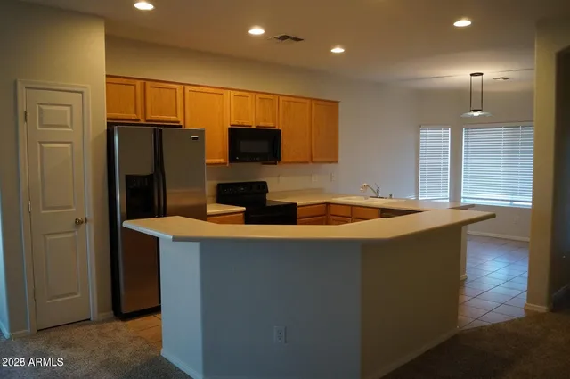 a kitchen with stainless steel appliances granite countertop a sink a refrigerator and a stove