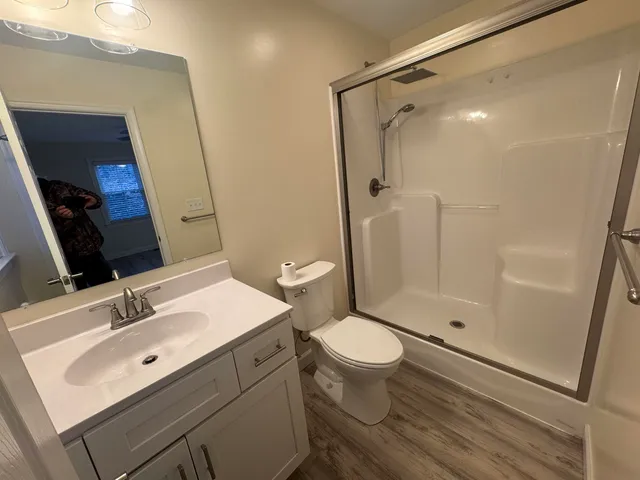 a bathroom with a sink toilet a mirror and shower