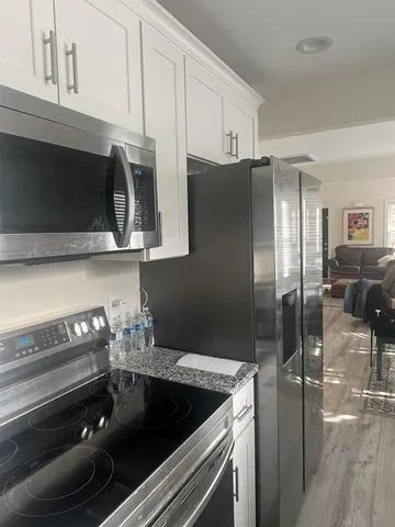 a kitchen with granite countertop a stove and a refrigerator