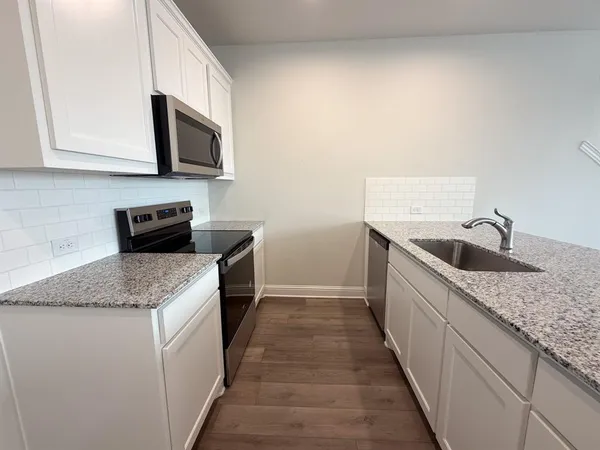 a kitchen with stainless steel appliances granite countertop a sink stove and microwave