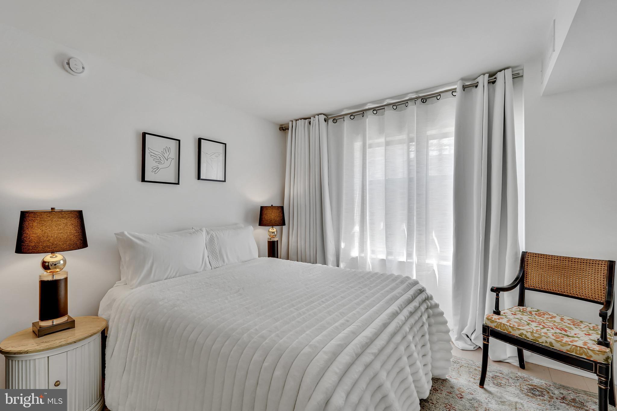3401 38th Street Northwest, Unit 407 Washington, DC 20016 - Photo 12 of 28 a bedroom with a bed and a chair