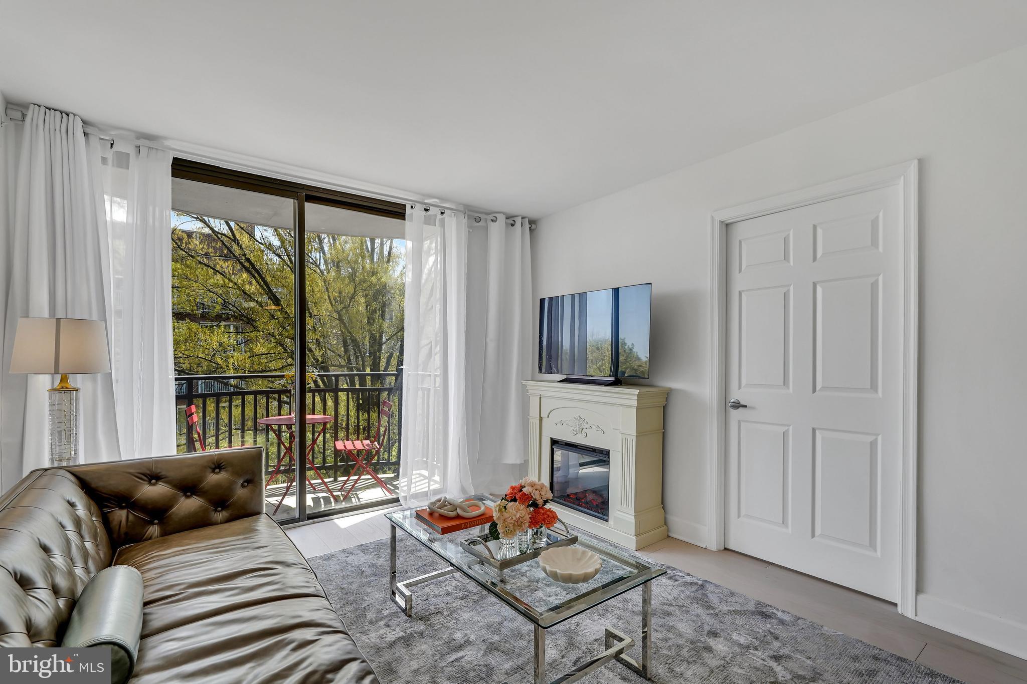 3401 38th Street Northwest, Unit 407 Washington, DC 20016 - Photo 18 of 28 a living room with furniture and a fireplace