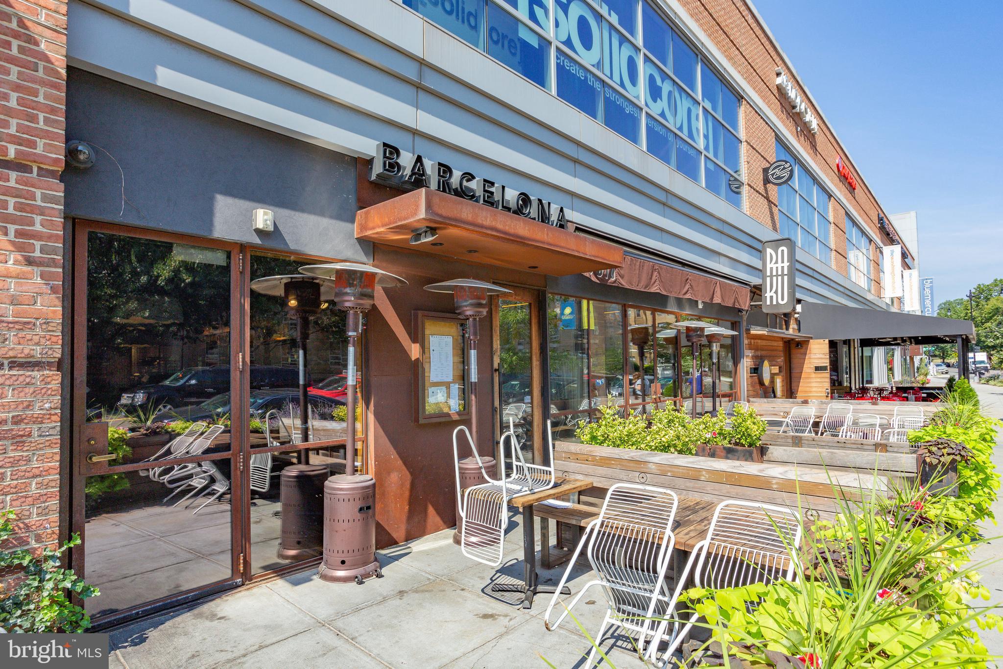 3401 38th Street Northwest, Unit 407 Washington, DC 20016 - Photo 24 of 28 a view of a cafe with a couple of people seating in front of a building