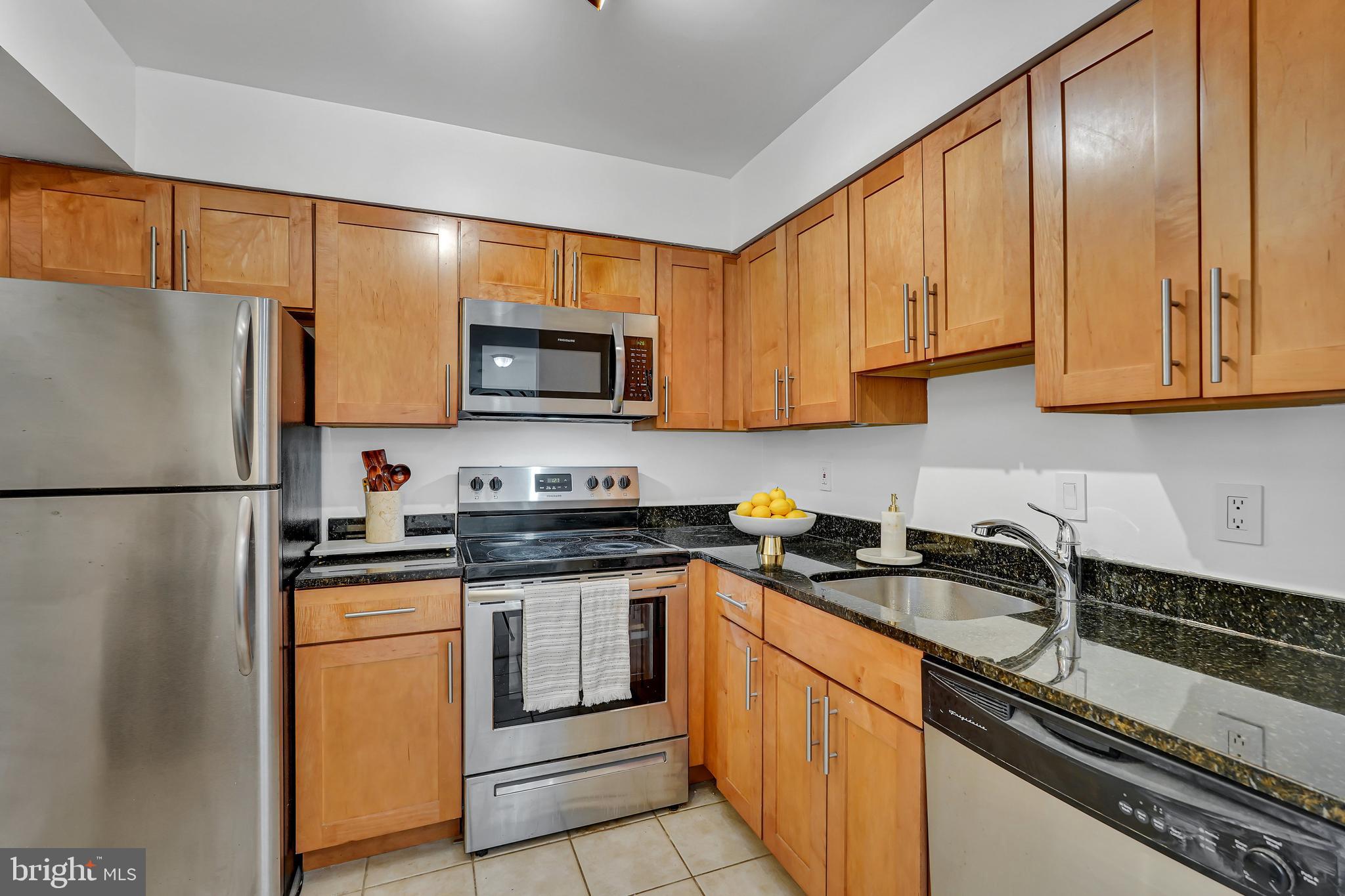 3401 38th Street Northwest, Unit 407 Washington, DC 20016 - Photo 3 of 28 a kitchen with stainless steel appliances granite countertop a refrigerator stove microwave and sink