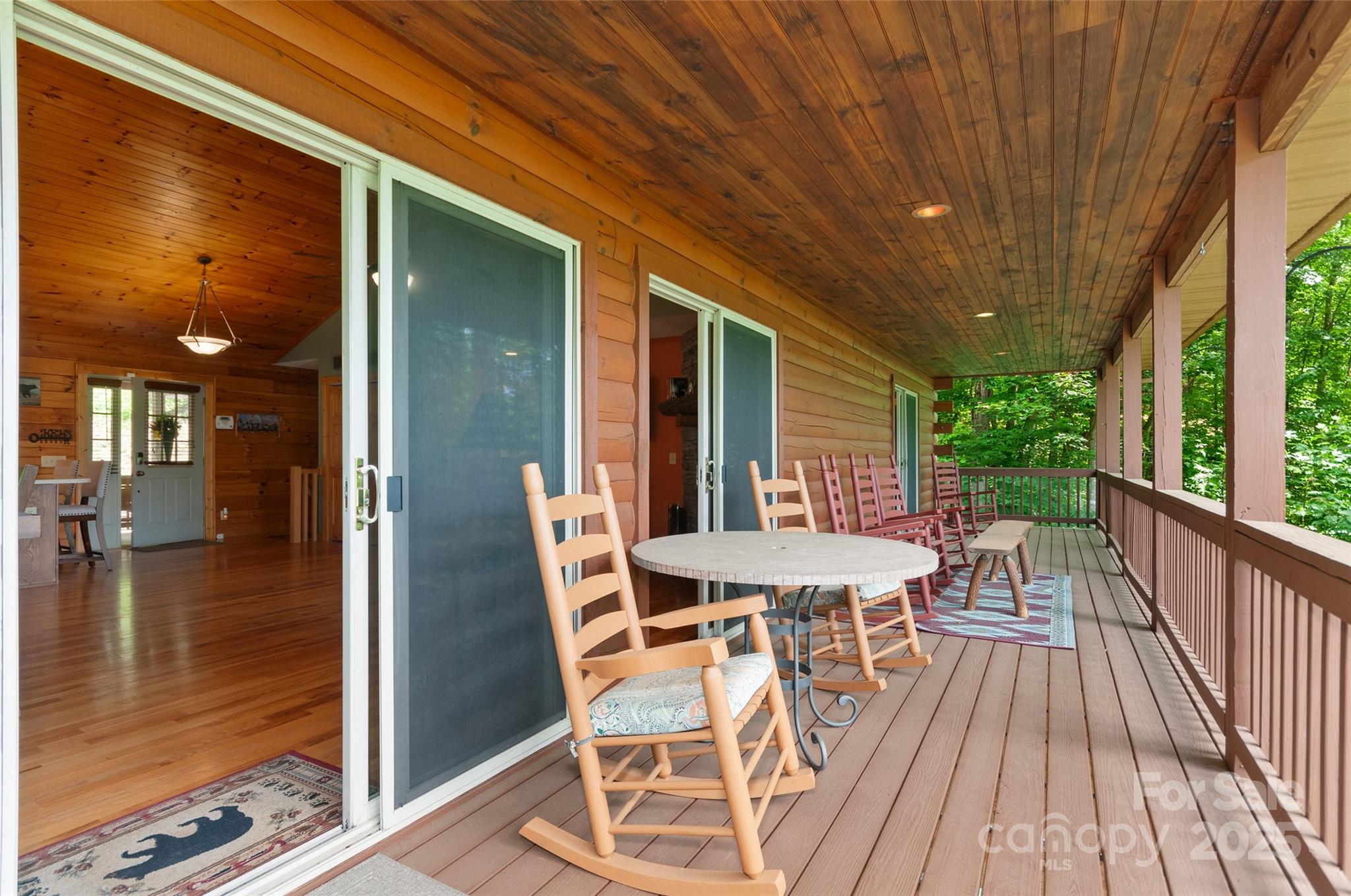 314 Prosperity Ridge Waynesville, NC 28785 - Photo 21 of 48 a view of a patio with table and chairs with wooden floor and floor to ceiling window