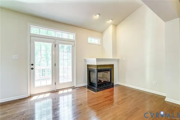 a view of a livingroom with wooden floor and a fireplace