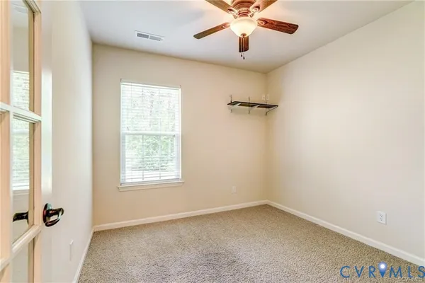 an empty room with a window and a fan