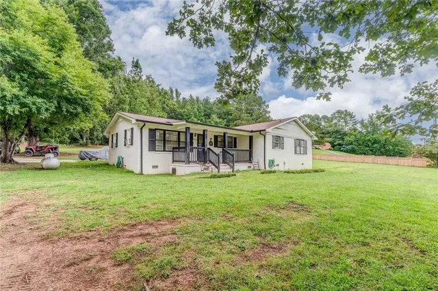 a view of a house with backyard and sitting area