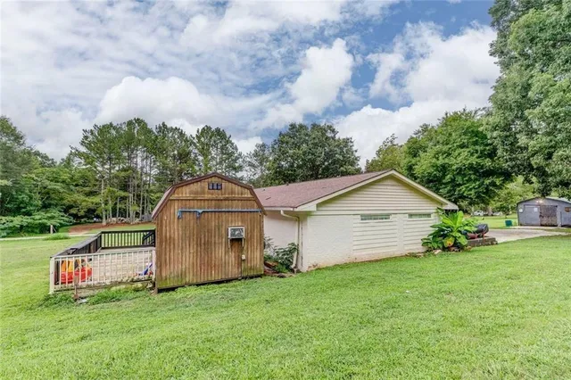 a view of a wooden house with a big yard and large trees