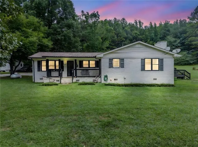 a front view of house with yard and trees in the background