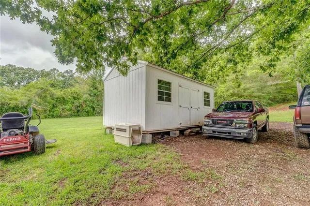 a backyard of a house with barbeque oven and trees