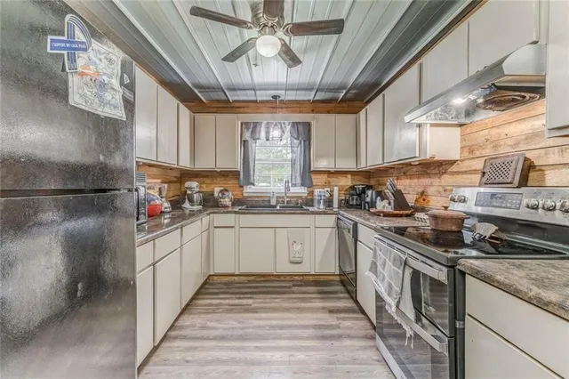 a kitchen with stainless steel appliances granite countertop a stove a refrigerator and a wooden cabinets