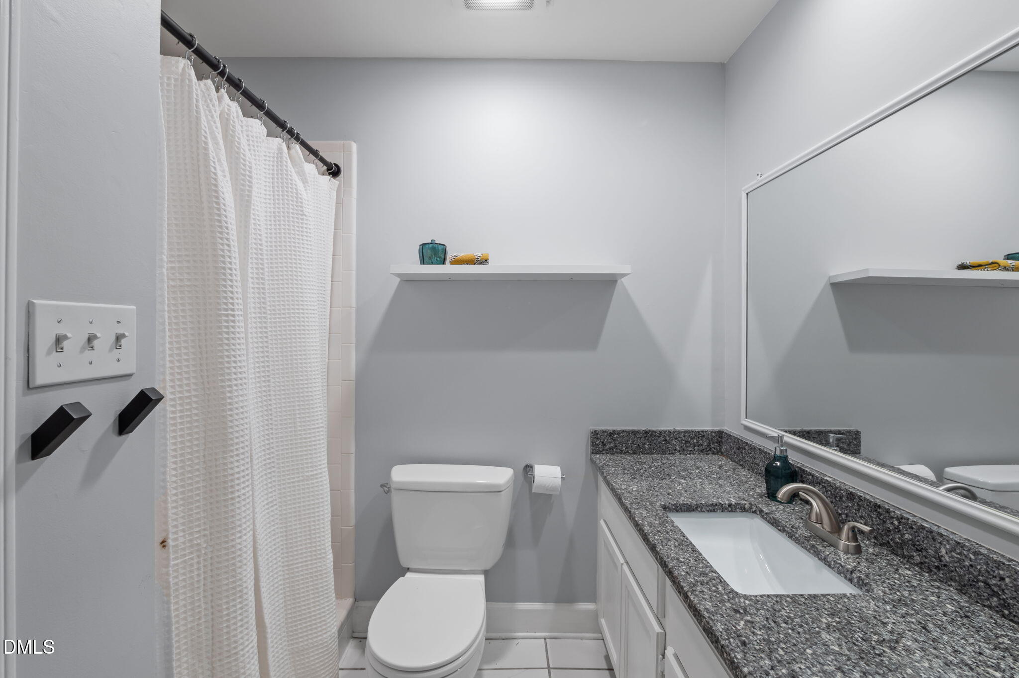 201 Simpson Street, Unit B Carrboro, NC 27510 - Photo 35 of 56 a bathroom with a granite countertop sink a toilet and a mirror